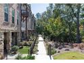 Attractive brick townhomes feature well-kept landscaping along a sidewalk at 418 Townly, Alpharetta, GA 30009