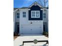 Charming townhome showcasing a two-car garage, blue and gray exterior, and well-maintained landscaping at 1621 Aiden Way # 57, Conyers, GA 30013