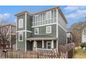 Angle view of green two-story home featuring a welcoming front porch and manicured lawn at 692 Rose Palm Ln, Atlanta, GA 30315