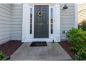Close-up of a front door with decorative wreath and house number, framed by white trim and sidelights at 327 Balaban Cir, Woodstock, GA 30188