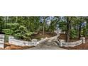Long driveway leading to a beautiful home surrounded by lush greenery and mature trees at 4395 Woodland Brook Se Dr, Atlanta, GA 30339