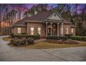Brick home with a large front porch and landscaped yard at 130 Wesleyan Way, Oxford, GA 30054