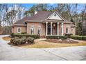 Brick home with a large front porch and landscaped yard at 130 Wesleyan Way, Oxford, GA 30054
