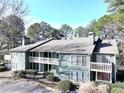 Two-story condo with multi-level porches, surrounded by mature trees and shrubbery at 4676 Vinings Central Se Run # 104, Atlanta, GA 30339