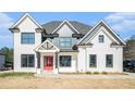 Charming two-story home with a red front door, black framed windows, and ample parking space at 1010 Nours Cir, Lawrenceville, GA 30045
