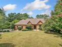 A single-Gathering home, beautifully landscaped, with a brick exterior, lush lawn, and concrete walkway at 3505 Watson Rd, Cumming, GA 30028