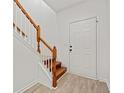 Bright entryway with wood stairs and light-colored flooring at 438 Lantern Wood Dr, Scottdale, GA 30079