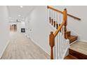 Light and airy hallway with wood stairs and light flooring at 438 Lantern Wood Dr, Scottdale, GA 30079