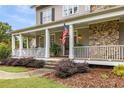 Spacious front porch with rocking chairs, white columns, and stone fireplace at 4130 Little Falls Dr, Cumming, GA 30041