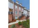 Townhome exterior with brick and white siding, featuring stairs and landscaping at 509 Burton Dr # 806, Alpharetta, GA 30009