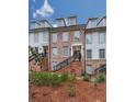 Three-story townhome building with brick and white accents, and black railings at 509 Burton Dr # 806, Alpharetta, GA 30009