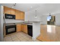 Modern kitchen with light wood cabinets, black appliances, and a breakfast bar at 285 Centennial Olympic Park Nw Dr # 1407, Atlanta, GA 30313
