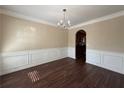 Elegant dining room featuring hardwood floors, chair-rail molding, and a classic chandelier at 308 Jarrod Oaks Ct, Loganville, GA 30052