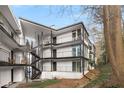 Modern condo building with black iron balconies and staircase, surrounded by mature trees at 1445 Monroe Ne Dr # B7, Atlanta, GA 30324