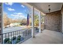 Covered porch with a view of the street and surrounding trees at 8967 Midlothian Ct, Winston, GA 30187