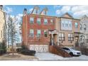 Two-story townhome with brick exterior, two-car garage, and a staircase leading to the entrance at 2445 Santa Rosa St, Alpharetta, GA 30009