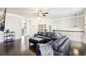 Spacious living room with dark hardwood floors, leather sectional sofa, and a modern fireplace at 2445 Santa Rosa St, Alpharetta, GA 30009