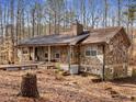 Stone-clad home featuring a charming wraparound porch and wooded surroundings at 5295 Ridge Rd, Douglasville, GA 30134