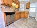 Modern kitchen with stainless steel dishwasher, wooden cabinets, and hardwood floors at 8504 Browns Mill Trce, Lithonia, GA 30038