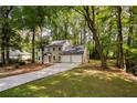 View of the gray home showing a new driveway, two-car garage and backyard access stairs at 2189 Wood Glen Se Ln, Marietta, GA 30067