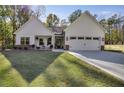 White farmhouse exterior with stone accents, two-car garage, and landscaped yard at 728 Harmony Rd, Temple, GA 30179