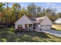 White farmhouse exterior with stone accents, two-car garage, and landscaped yard at 728 Harmony Rd, Temple, GA 30179