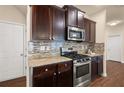 Kitchen features dark brown cabinets, granite countertops, and stainless steel appliances at 116 Centennial Ridge Dr, Acworth, GA 30102