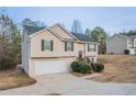 Split-level home with light siding, black shutters, a garage and a large yard is on display at 100 Arthurs Ln, Covington, GA 30016