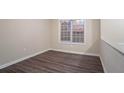 A clean and bright room with wood floors is illuminated by natural light from a window at 100 Arthurs Ln, Covington, GA 30016