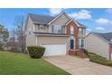 Two-story house with brick and siding exterior, attached garage, and landscaping at 415 Gresham Dr, Stockbridge, GA 30281