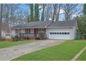 House exterior showcasing a white ranch home with a red door and attached garage at 4179 White Rd, Snellville, GA 30039