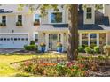 Close up of the front entrance with a well maintained lawn, flowers, and two car garage on the left at 1164 Pine Grove Dr, Alpharetta, GA 30009