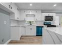 Bright kitchen featuring white cabinets, stainless steel appliances, sleek countertops and a waterfall island at 6467 Joanna St, Lithia Springs, GA 30122