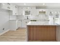 Modern kitchen with white cabinets, quartz island, and wood flooring at 6467 Joanna St, Lithia Springs, GA 30122