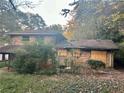 Brick house with damaged roof and boarded windows at 3128 Columbia Woods Dr, Decatur, GA 30032