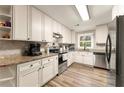 Modern kitchen with white cabinets, stainless steel appliances, and granite countertops at 3570 Knoll Crest Trl, Buford, GA 30519