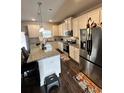 Spacious kitchen with granite island, stainless steel appliances, and dark hardwood floors at 11118 Benton, Covington, GA 30014