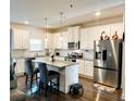 Modern kitchen with white cabinets, granite countertops, and stainless steel appliances at 11118 Benton Woods Dr, Covington, GA 30014