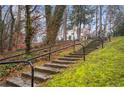 Stone steps leading to a charming house with black railings, surrounded by lush greenery at 1992 Walthall Nw Dr, Atlanta, GA 30318