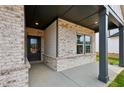 A welcoming covered front porch features stone columns and a brick facade leading to a glass-paneled front door at 3921 Brushy St, Powder Springs, GA 30127