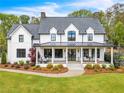 Elegant two-story farmhouse with a metal roof and large front porch at 103 Arbor Oaks Dr, Canton, GA 30115