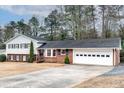 Ranch style home with brick and white siding, attached garage, and spacious yard at 1833 Queens Way, Chamblee, GA 30341