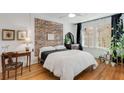 Cozy bedroom with brick accent wall, hardwood floors, and abundant plants at 974 Greenwood Ne Ave # 2, Atlanta, GA 30306