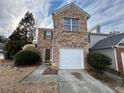 Brick townhouse with a white garage door and landscaping at 1635 River Main Ct, Lawrenceville, GA 30044