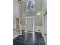 Two-story foyer with dark marble flooring, a white door, and a staircase at 295 Creekview Trl, Fayetteville, GA 30214