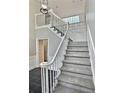 Elegant staircase with white railings and gray carpeting at 295 Creekview Trl, Fayetteville, GA 30214