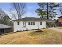 A painted brick house sits on a grassy hill with blue skies and mature trees at 2724 Larkspur Se Dr, Atlanta, GA 30316