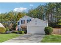 Two-story house with attached garage, American flag, and wooded backdrop at 5785 Stephens Mill Dr, Sugar Hill, GA 30518