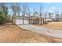 Single-story brick and siding home featuring a two-car garage and a spacious driveway at 1850 Cashmere Ct, Lithonia, GA 30058