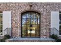 A stylish brick home featuring a large, arched front door with black framing and white shutters at 2515 Habersham Nw Rd, Atlanta, GA 30305